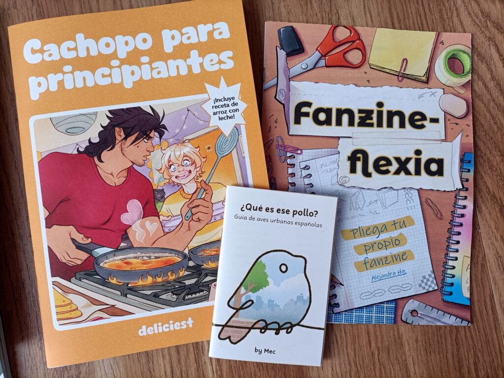 Foto de varios fanzines sobre una superficie plana: cachopo para principiantes de Deliciest, Fanzineflexia de Alejandra y ¿Qué es ese pollo? de Mec