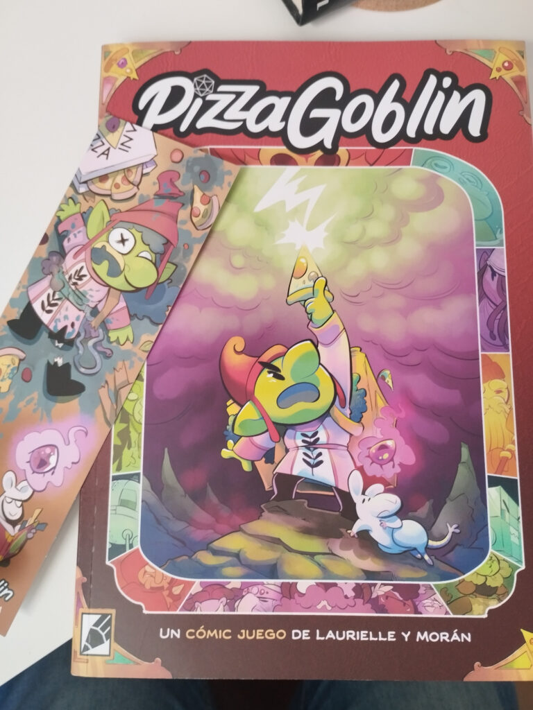 Foto del cómic Pizza Goblin sobre una mesa con un marcapáginas