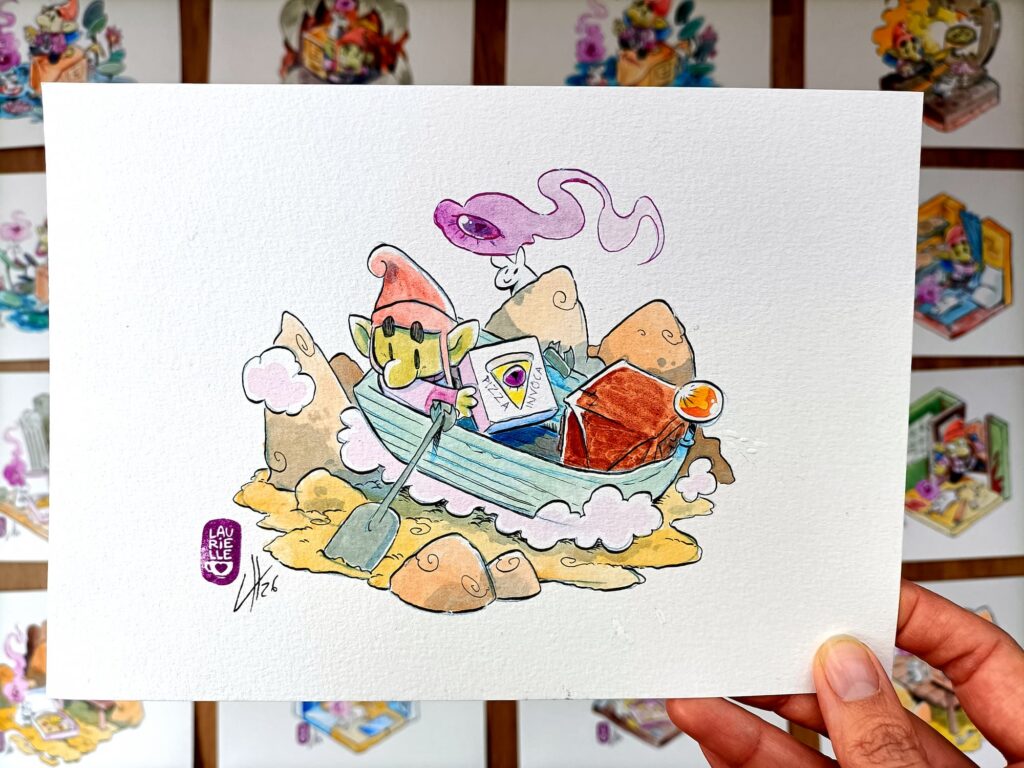 Foto de una mano sosteniendo una acuarela original de Pizza Goblin con la goblin remando en una barca enmedio de un desierto