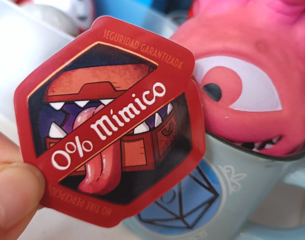 Foto de una pegatina de 0% mímicos sostenida al lado de un contemplador antiestrés